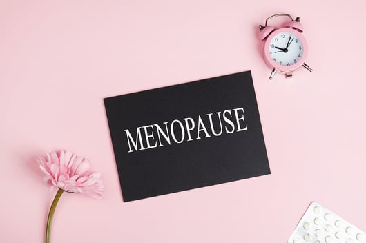 Pink image with "Menopause" sign across middle - Menopause Awareness Month 2022