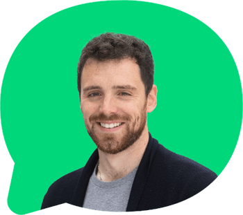 Headshot of Nathan Rhodes, smiling at the camera. Green decorative bubble graphic behind.